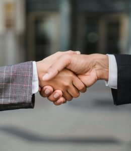 A close-up of two businesspeople shaking hands, symbolizing cooperation and partnership.